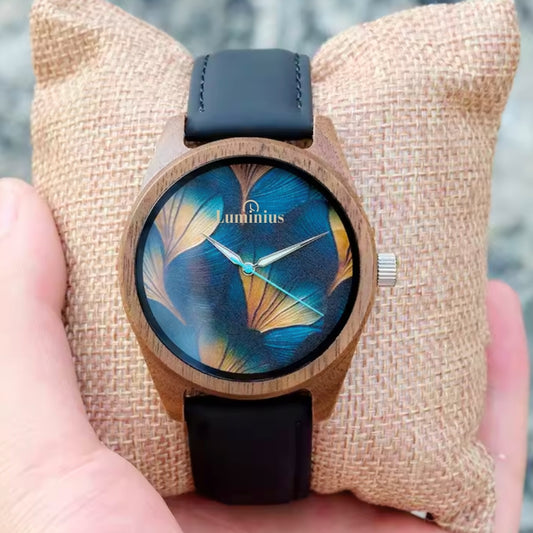 Men's and Women's Wooden watch with blue floral design on the face, held against a textured beige background.