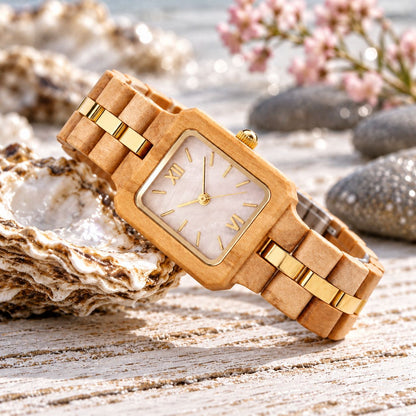 The Pink Pearl wood watch resting on its side among oyster shells and pebbles