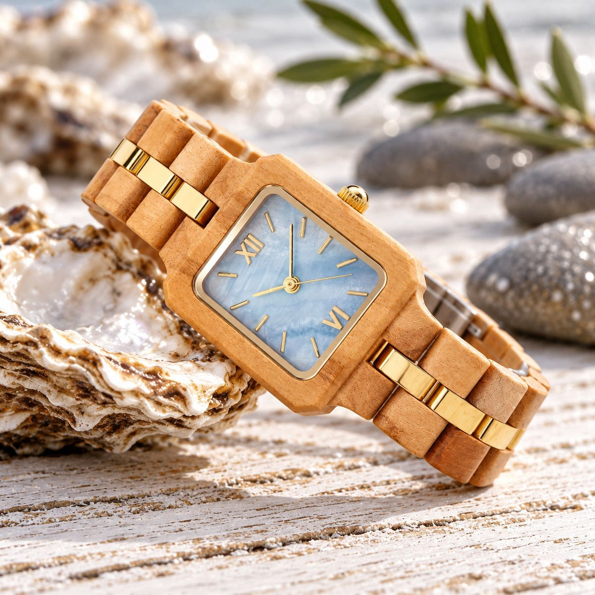The Blue Pearl wood watch resting on its side among oyster shells and olive leaves