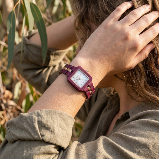 Woman wearing The Rosewood slim wood watch among olive leaves