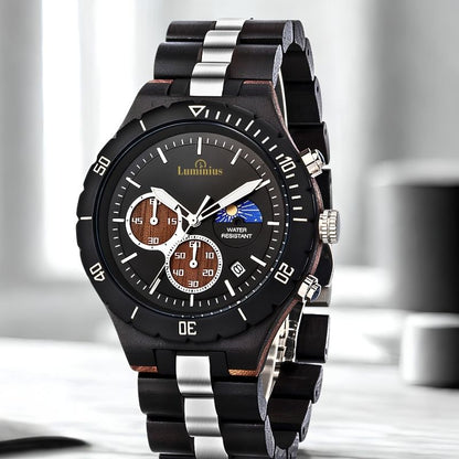 A Luminus men's watch with a black and silver metallic link bracelet, a black bezel, and a black dial featuring brown subdials and a moon phase indicator.