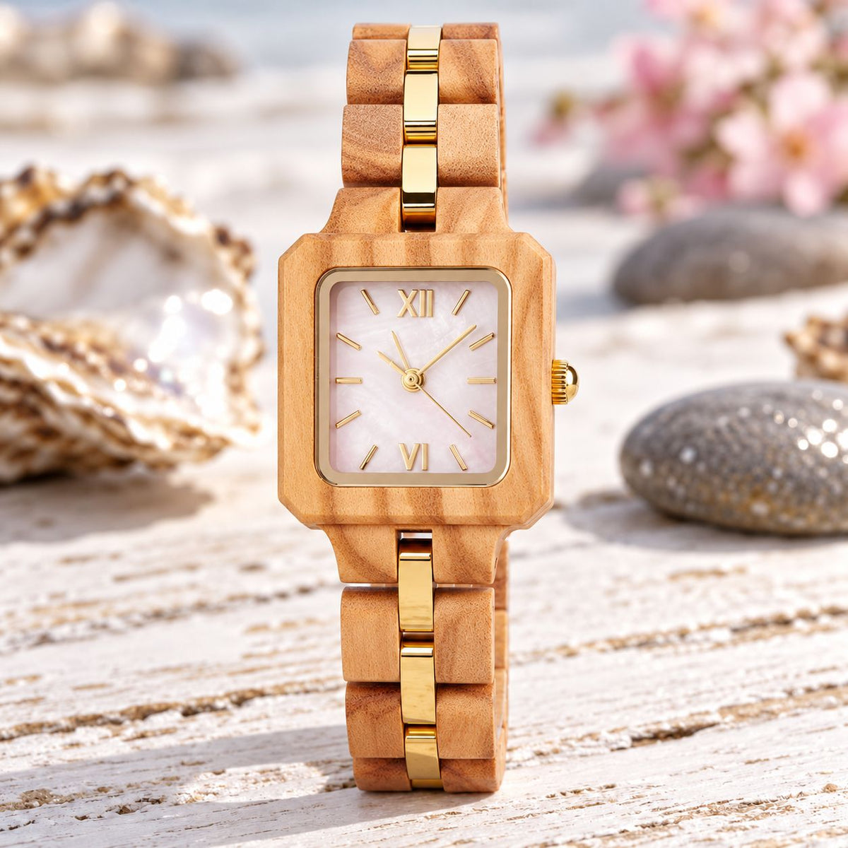 The Pink Pearl women's olive wood watch standing among oyster shells and pink blossoms